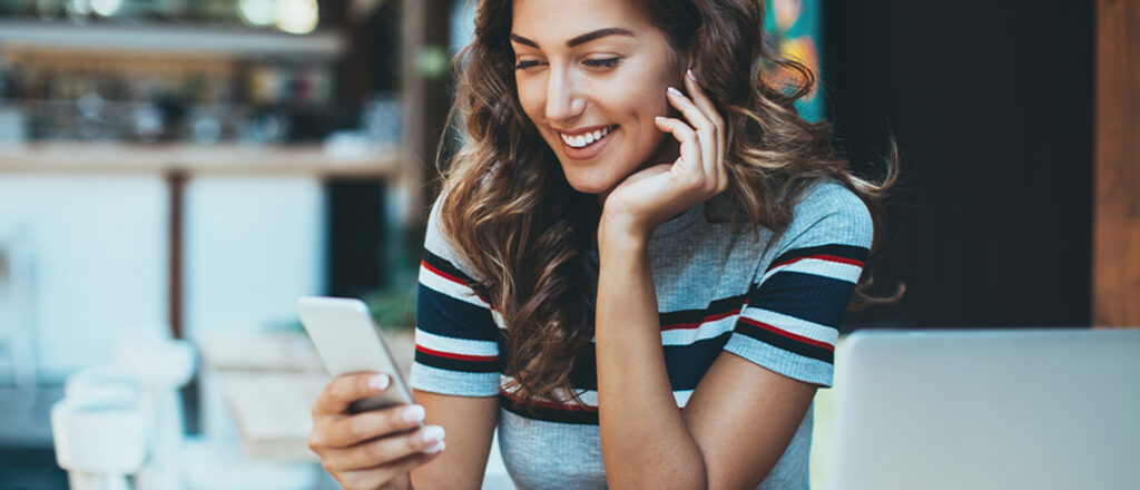 Young woman smiling looking at her phone