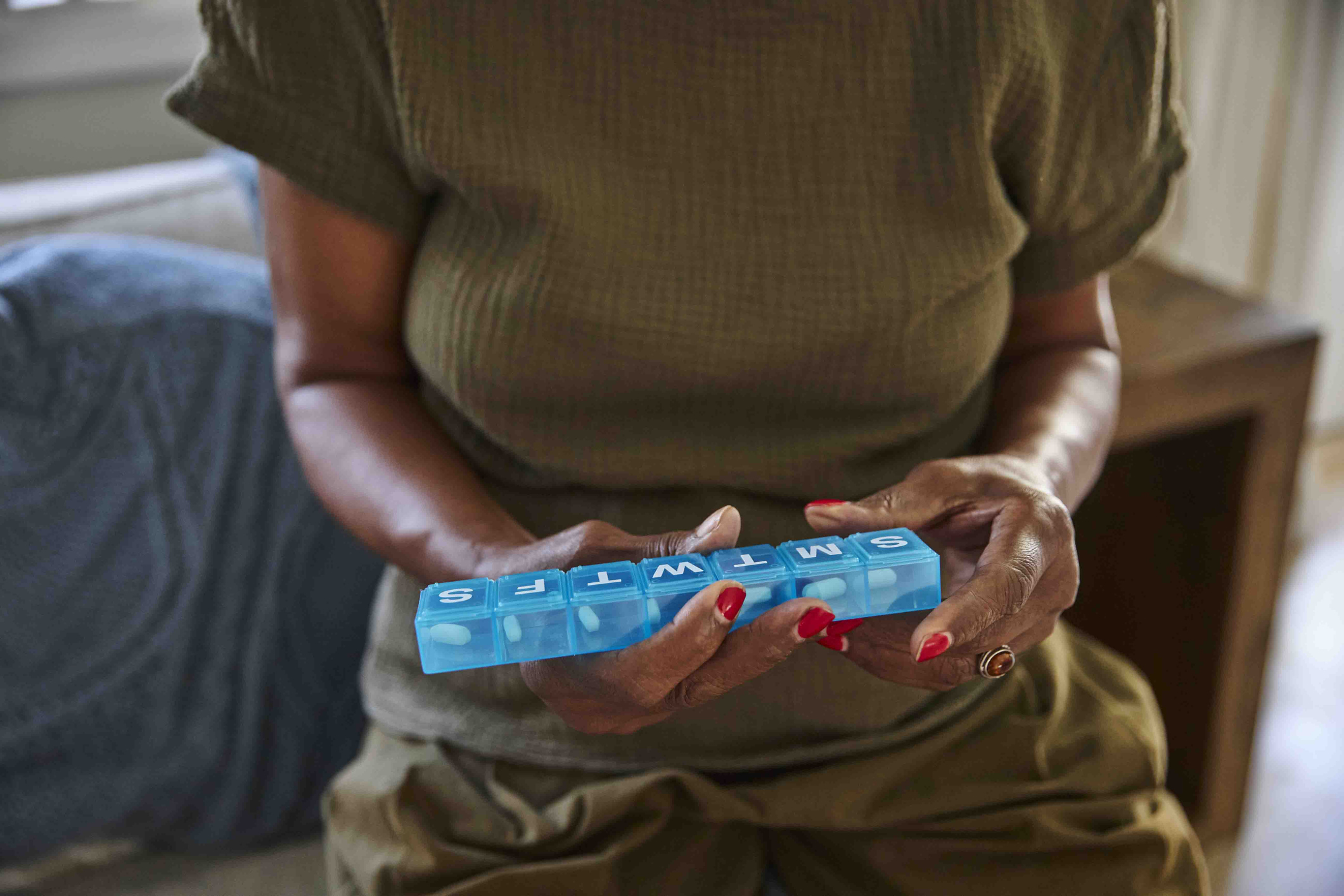 Person holding weekly prescription box