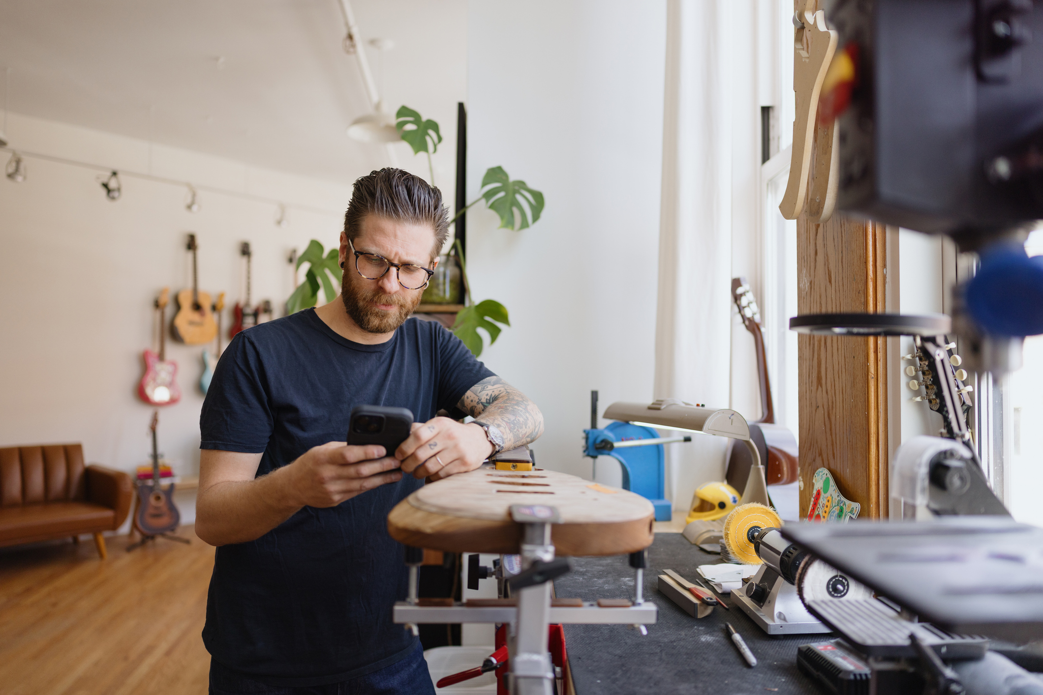 Man on cellphone in his guitar shop