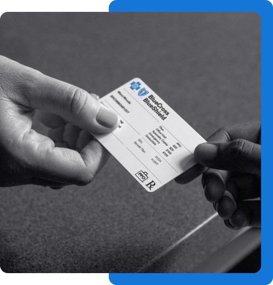 Adult handing their Blue Cross Blue Shield insurance card to a Health Care Provider