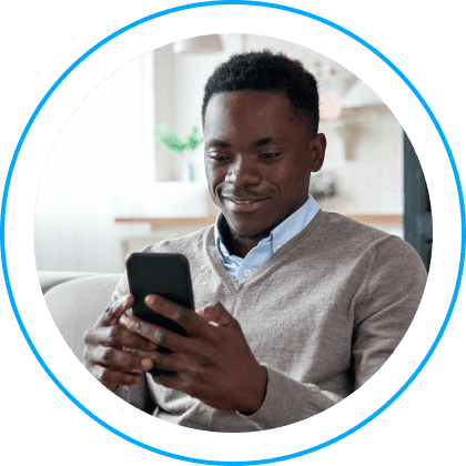 Young adult man smiling while navigating the BlueKC app on his phone