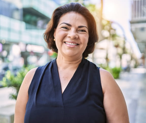 Woman posing for picture in city setting.
