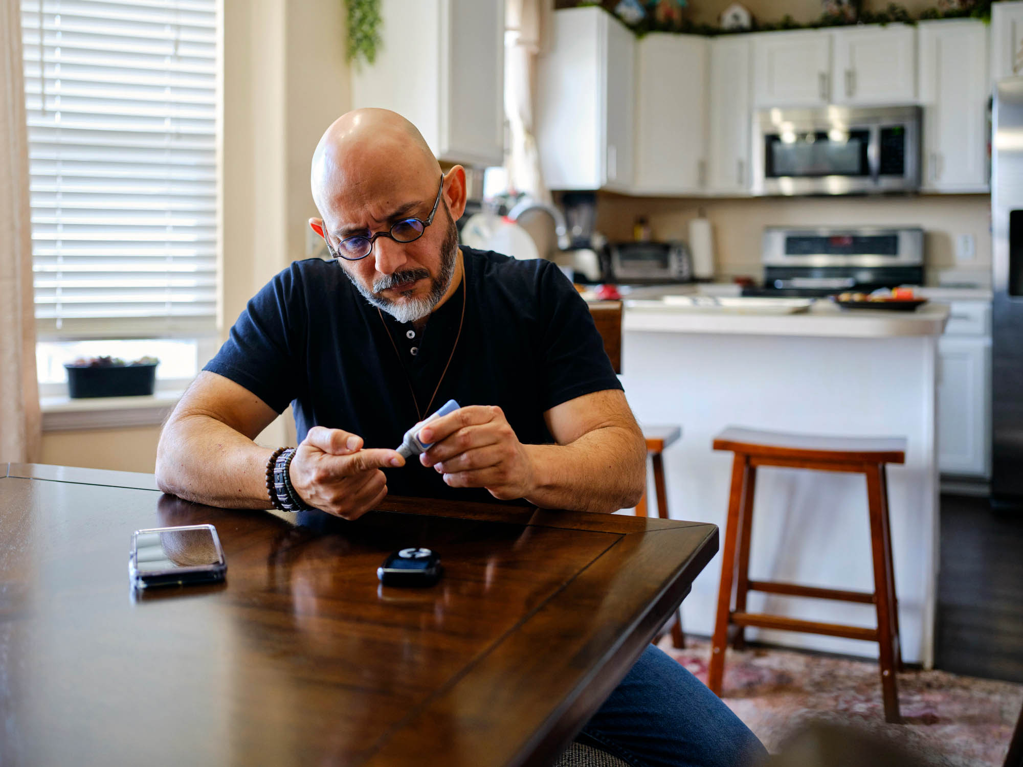 Man with glasses tests his blood sugar